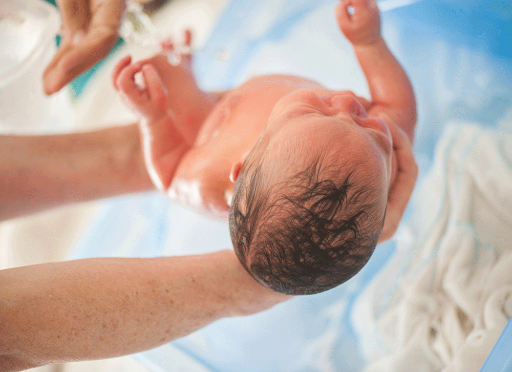 Newborn held above water